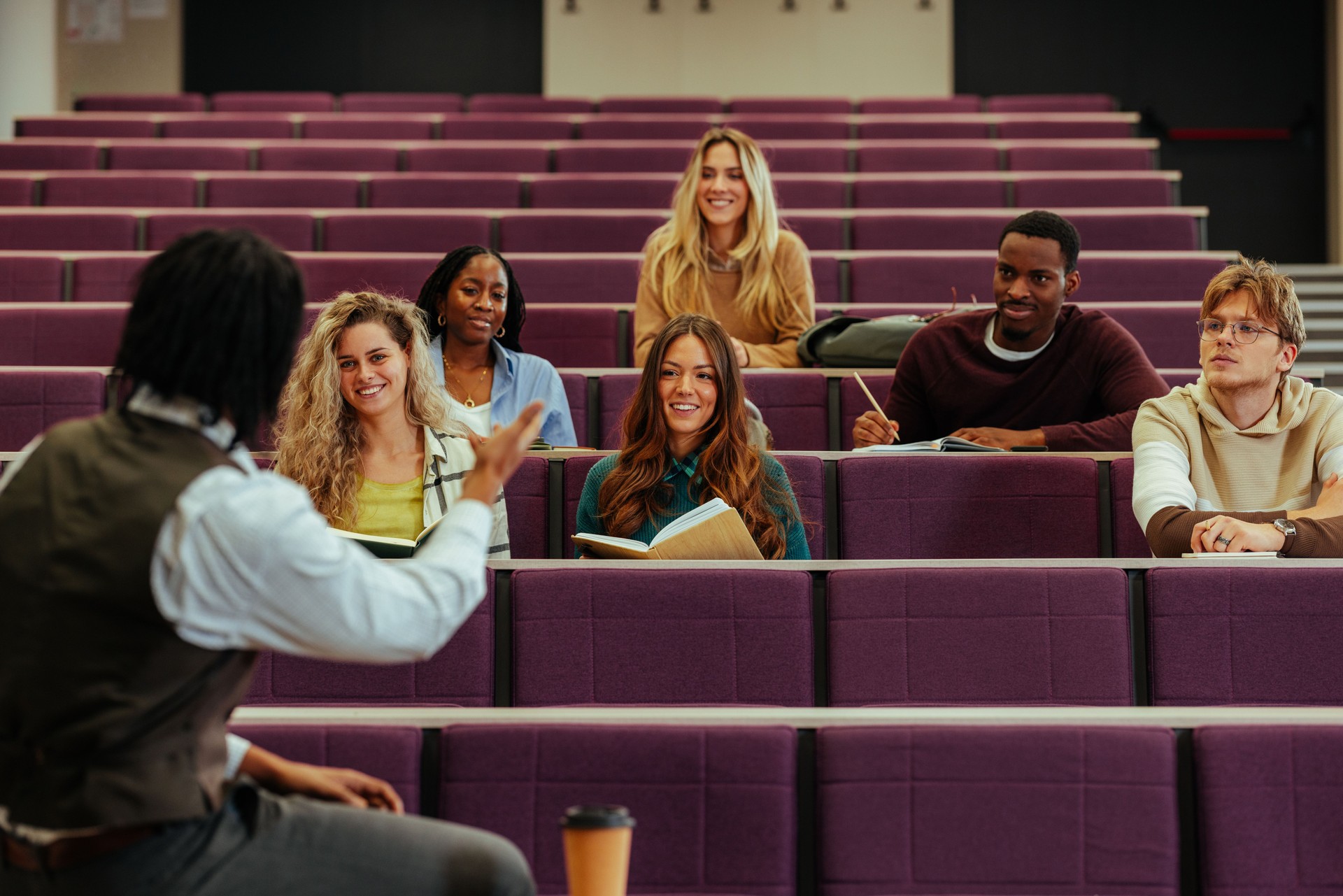 Un professeur discute avec des étudiants lors d’un cours universitaire dans un amphithéâtre